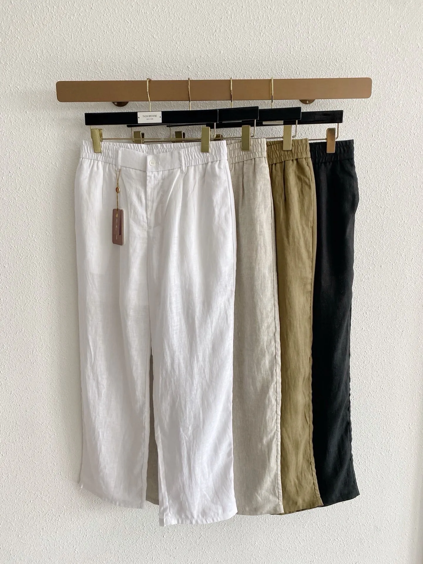 Loro Piana elastic waist linen wide-leg pants. Fabric: 100% Italian rain dew linen, the same fabric as Series vests and shirts. It has been processed by the brand's softening process to weaken the stiff and prickly feeling of the linen. It has a natural clear linen texture, matte low saturation texture, breathable heat dissipation, and is a must in spring and summer. It has loose and natural wrinkles after washing. Style and details: Loose straight wide-leg cut, the trousers are loose and loose, not clinging to the legs, to accommodate all kinds of leg shapes, the trousers are long enough to expose the ankles, refreshing and neat; Waistband design: single button on the front + standard placket, full elastic waist on both sides, no sense of restraint, taking into account the regular appearance of the trousers and the comfort of home leisure, it comes with belt loops to match with belts; The minimalist front panel without pleats is visually clean and neat; the hidden diagonal pockets on both sides are low-key and have no exposed logo; the straight trouser legs do not need to be deliberately rolled, and the natural drape creates a relaxed atmosphere. Color choices: pure white, native hemp Beige, Khaki olive green, matte black, covering all scenarios of commuting, vacation, and daily life. Style positioning: Italian holiday relaxed style, minimalist commuting, new Chinese casual style, same style unisex version for men and women, focusing on high-end complete sets without logos. Sizes:S-4XL